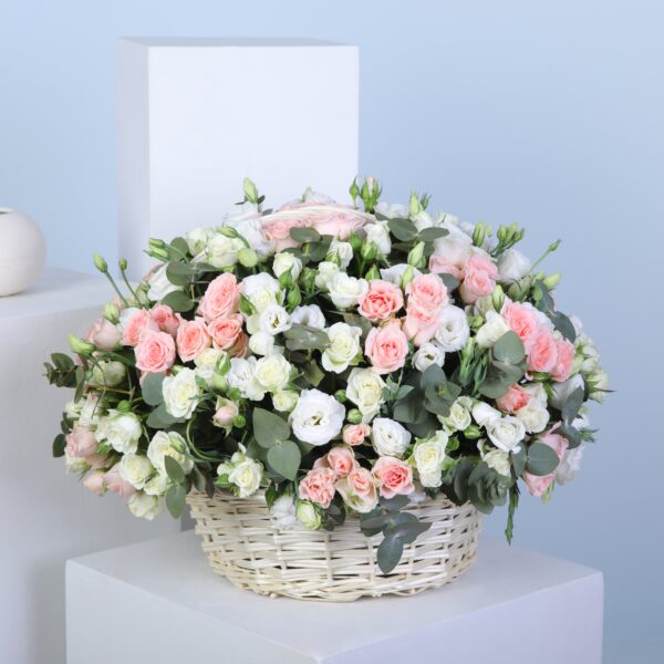 Pastel bloom flower basket with soft pink sweet sara roses, white spray roses, lisianthus, and eucalyptus stems.