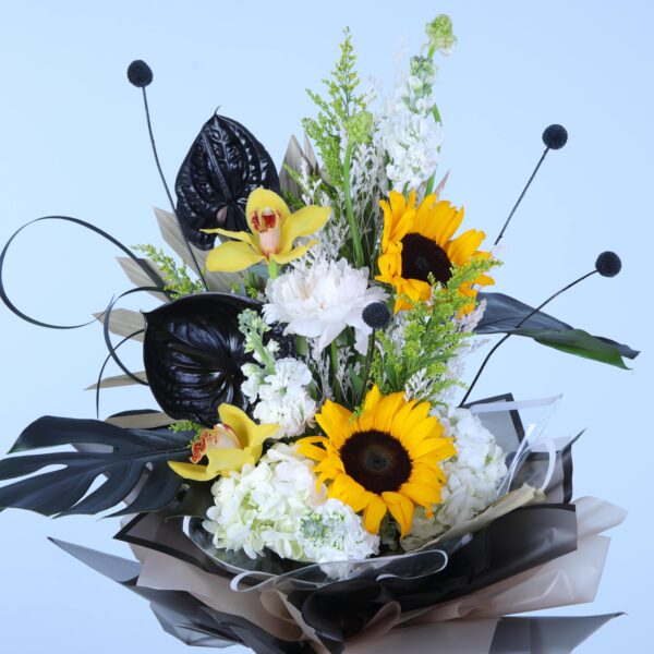 An energetic bouquet of sunflowers with striking black leaves elegantly displayed on a pedestal.