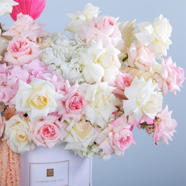 An exquisite flower box with white hydrangeas, pink Ohara roses, and dry leaves, perfect for special occasions or elegant gifts.