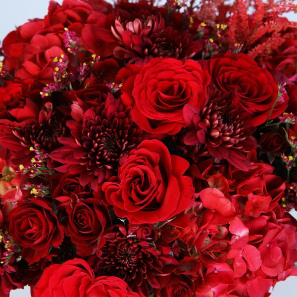 A stunning arrangement of red flowers beautifully displayed in a clear glass vase.