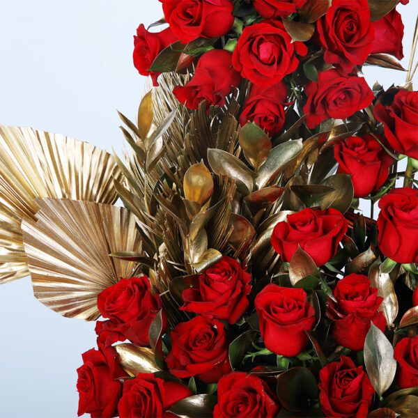 Stunning 50 red roses with golden accents in an elegant wicker basket.