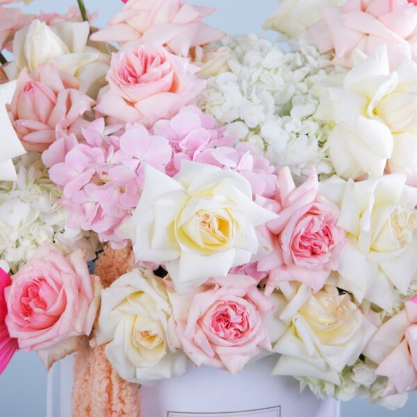 A luxurious arrangement of white hydrangeas and pink Ohara roses, beautifully accented with dry leaves in a chic flower box.