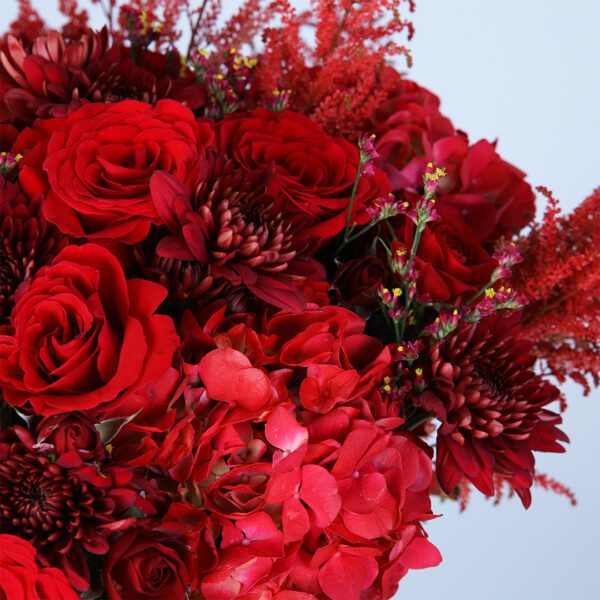 Lush red blooms artfully arranged in a sleek glass vase to make a bold statement.