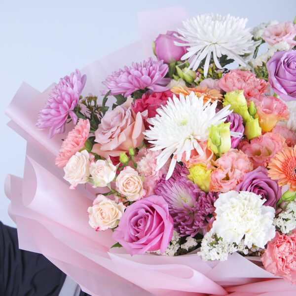 Delicate pink hydrangea and a variety of mixed flowers in a hand-tied bouquet.