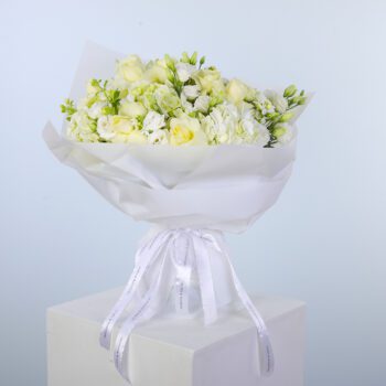 Elegant white blooms beautifully arranged in a bouquet with white wrap.