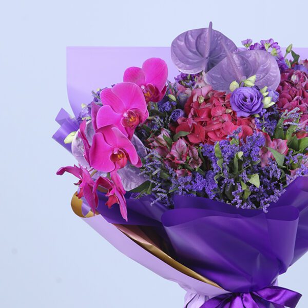 A vibrant purple bouquet with a variety of blooms, creates a sophisticated floral centerpiece.