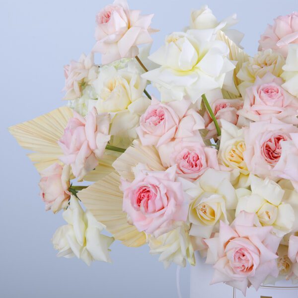 A charming white box filled with pink and white flowers, ideal for celebrations or as a delightful gift.