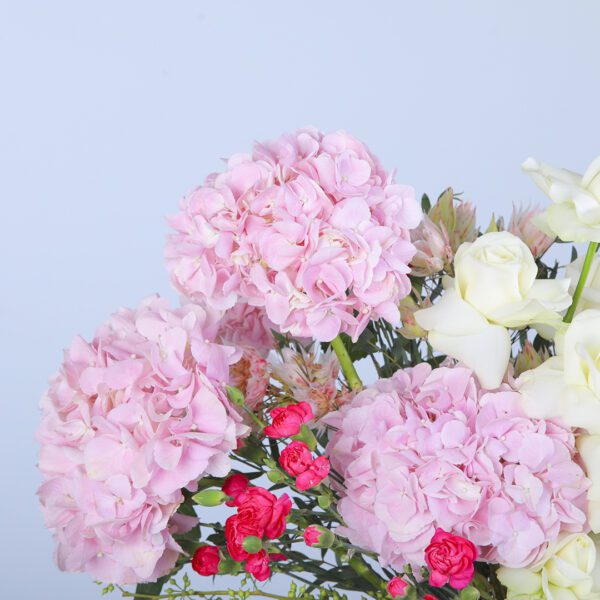 A vibrant bouquet of pink hydrangeas and white roses, tied with a delicate ribbon.