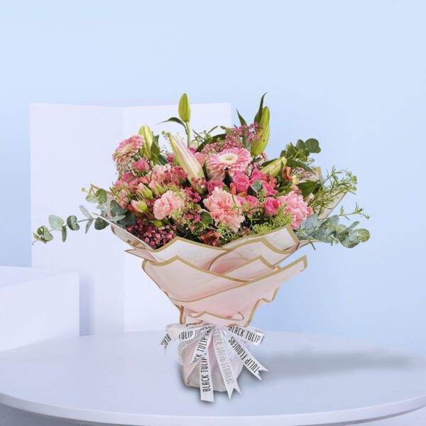 A beautiful bouquet of pink flowers tied up with a white ribbon.