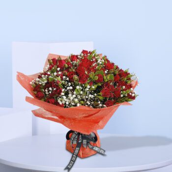 A bouquet of 20 red baby roses with added greenery and gypso wrapped in red paper and tied with black ribbon.