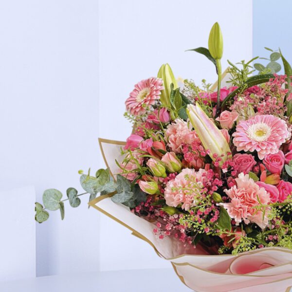 A beautiful bouquet of pink flowers tied up with a white ribbon.